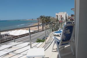 a beach with a balcony overlooking the ocean at Hotel Miramare in Marina di Ragusa