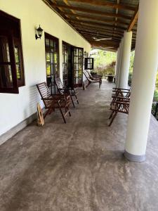 een groep schommelstoelen op een veranda bij Diyagal Villa 