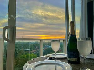 a table with a bottle of wine and two glasses at Aeonsky apartment Negombo beach and airport in Negombo