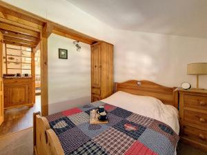 um quarto com uma cama com uma colcha em Appartement Saint-Martin-de-Belleville, 2 pièces, 4 personnes - FR-1-344-860 em Saint-Martin-de-Belleville