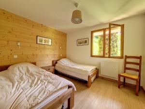 a bedroom with two beds and a chair in it at Appartement en duplex, 3 pièces, au pied des pistes, balcon, casier à ski, classé 3 flocons or - FR-1-344-908 in Saint-Martin-de-Belleville