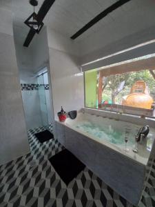 a bathroom with a large tub with a window at La Bota del Gigante in Gigante