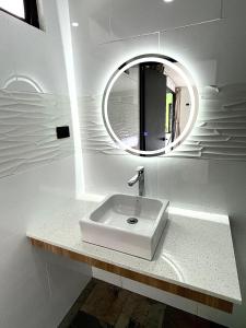 a white bathroom with a sink and a mirror at Pura Natura Lodge Manuel Antonio in Manuel Antonio