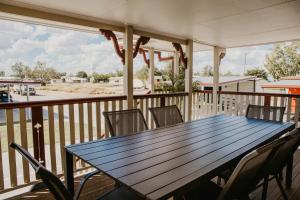 - une table et des chaises sur une terrasse couverte offrant une vue sur la plage dans l'établissement Winton Outback Motel, à Winton