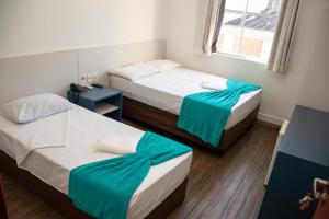 a room with two beds and a window at Zurique Sorocaba Hotel in Sorocaba
