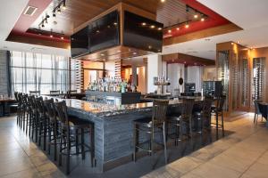 a bar in a restaurant with a bunch of stools at Four Points by Sheraton Edmonton International Airport in Nisku