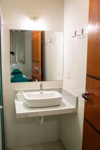 a bathroom with a sink and a large mirror at Zurique Sorocaba Hotel in Sorocaba