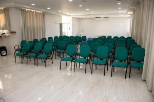 una sala conferenze con sedie verdi in una stanza di Zurique Sorocaba Hotel a Sorocaba
