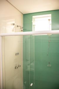 a bathroom with a glass shower and a window at Zurique Sorocaba Hotel in Sorocaba
