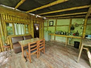 a dining room with a table and a kitchen at Kamala Surf & Backpacker Hostel in Montañita