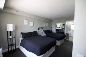 a bedroom with two beds and a bathroom at Modern Beach Condo-Daytona Beach in Daytona Beach +14 photos