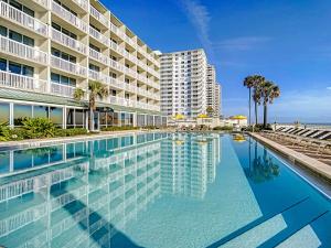 a swimming pool in front of a large building at Modern Beach Condo-Daytona Beach in Daytona Beach