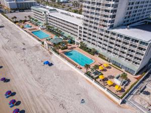 z góry widok na plażę z parasolami i hotel w obiekcie Modern Beach Condo-Daytona Beach w mieście Daytona Beach