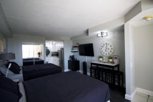 1 dormitorio con 1 cama y reloj en la pared en Modern Beach Condo-Daytona Beach en Daytona Beach