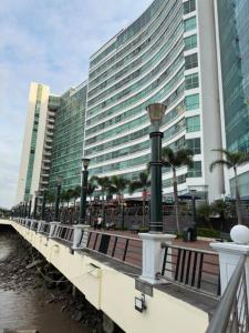 a bridge over a river with a large building at Encanto de la Perla del Pacífico in Guayaquil