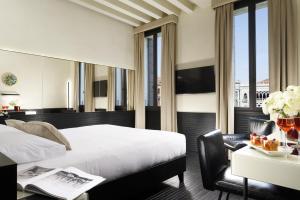a hotel room with a bed and a desk with a table sidx sidx at Hotel L'Orologio - WTB Hotels in Venice
