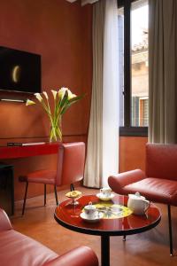 a living room with a coffee table and chairs at Hotel L'Orologio - WTB Hotels in Venice