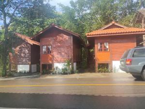 twee kleine houten huizen aan de kant van een weg bij เฮือนฮิมธารโฮมสเตย์ in Ban Pang Champi