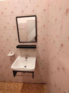 een badkamer met een wastafel en een spiegel aan de muur bij เฮือนฮิมธารโฮมสเตย์ in Ban Pang Champi