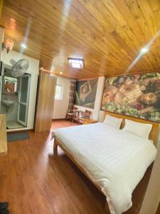 a bedroom with a white bed in a wooden ceiling at ROSE MOTEL in Sa Pa