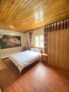 a bedroom with a large bed and a wooden ceiling at ROSE MOTEL in Sa Pa