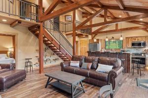 a living room with brown leather furniture and a kitchen at Hot Shot Hideaway in Custer