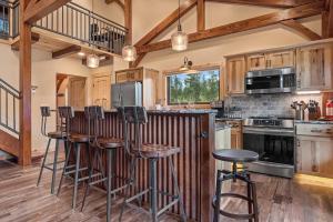 eine Küche mit Holzschränken und einer Theke mit Stühlen in der Unterkunft Hot Shot Hideaway in Custer