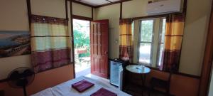 Habitación con cama, lavabo y ventanas. en Mango House Apartments, en Panglao
