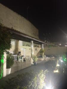 an outdoor patio at night with chairs and plants at Aeroporto in Salvador +10 photos