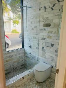 uma casa de banho com um WC e uma cabina de duche em vidro. em Woollahra house beautiful 3 bedroom terrace em Sydney