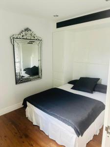 um quarto com uma cama com um espelho na parede em Woollahra house beautiful 3 bedroom terrace em Sydney