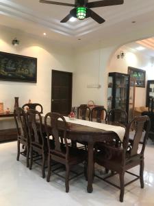 - une table à manger avec des chaises et un ventilateur de plafond dans l'établissement Samba Guest House, Kota Bharu, Kelantan, à Kota Bharu
