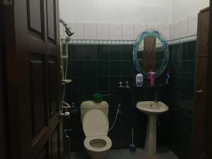 La salle de bains est pourvue de toilettes, d'un lavabo et d'un miroir. dans l'établissement Samba Guest House, Kota Bharu, Kelantan, à Kota Bharu