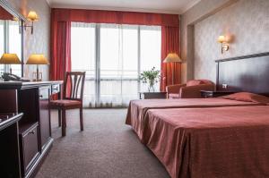 a hotel room with a bed and a chair at Gladiola 4-star in Golden Sands