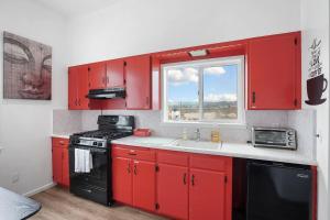 uma cozinha com armários vermelhos, um lavatório e uma janela em Budget Cozy Private Rooms Shared Bath near SFO em South San Francisco