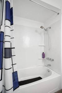 uma banheira branca com uma cortina de chuveiro na casa de banho em Budget Cozy Private Rooms Shared Bath near SFO em South San Francisco