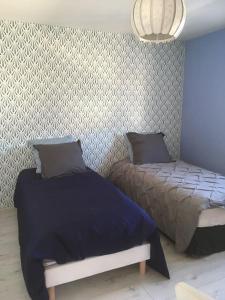 a bedroom with two beds and a wall at MAISON DE VACANCES 4 Clés - BORD DE MER DENNEVILLE PLAGE in Denneville