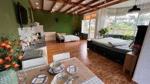 een woonkamer met een bed en een keuken met een tafel bij An Yên Villa Đà Lạt in Da Lat