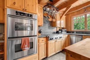 a kitchen with wooden cabinets and stainless steel appliances at Three-Bedroom House in Stevenson +39 photos