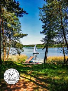 a sailboat on a dock with a boat in the water at Ostoja Stacze in Stacze