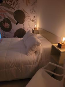 a bedroom with a white bed with a flowery wall at Departamentos Ines 1 in Junín