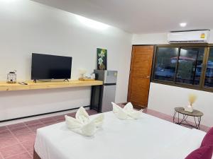 dwa łóżka w pokoju z telewizorem na ladzie w obiekcie KT Camp w mieście Haad Rin