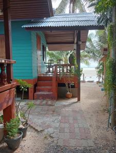 une maison bleue avec une terrasse couverte à côté de la plage dans l'établissement Free Concept Beach Resort, à Srithanu