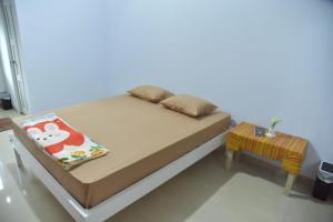 1 dormitorio con cama y mesa pequeña en Toraja Dannari Homestay, en Rantepao