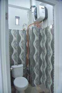 y baño con aseo y cortina de ducha. en Toraja Dannari Homestay en Rantepao