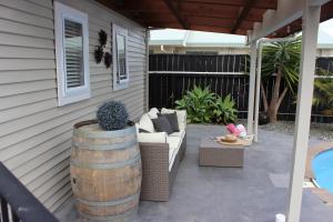 a patio with a couch and a barrel at The Pool House Bed & Breakfast - Napier in Napier