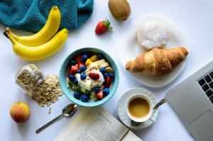 una mesa con un tazón de cereales y un tazón de fruta en The Pool House Bed & Breakfast - Napier en Napier