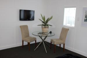 een kamer met een tafel en twee stoelen en een televisie bij The Pool House Bed & Breakfast - Napier in Napier