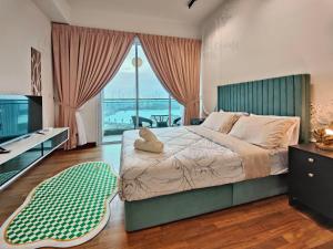 a bedroom with a bed with a television and a balcony at Paragon Suites CIQ Homestay by WELCOME HOME in Johor Bahru