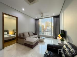 Soho suites klcc by Homestay في كوالالمبور: غرفة معيشة مع أريكة ونافذة كبيرة